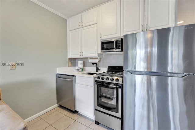 kitchen featuring light tile patterned flooring, white cabinetry, ornamental molding, stainless steel appliances, and decorative backsplash