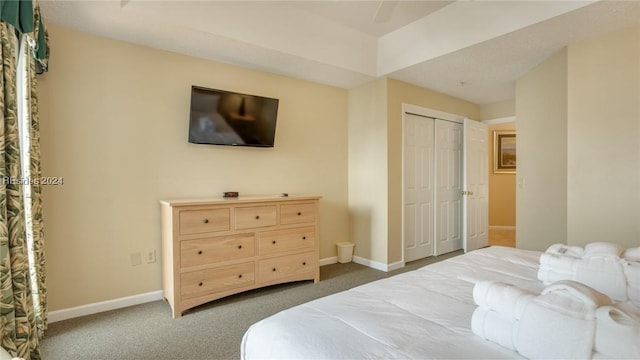 bedroom with dark carpet and a closet