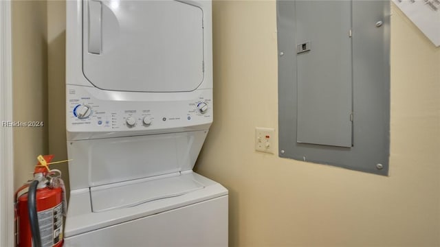 washroom with stacked washer / drying machine and electric panel