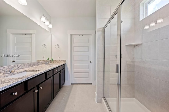 bathroom with tile patterned flooring, vanity, and a shower with shower door