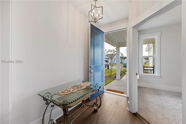 entryway with carpet and an inviting chandelier