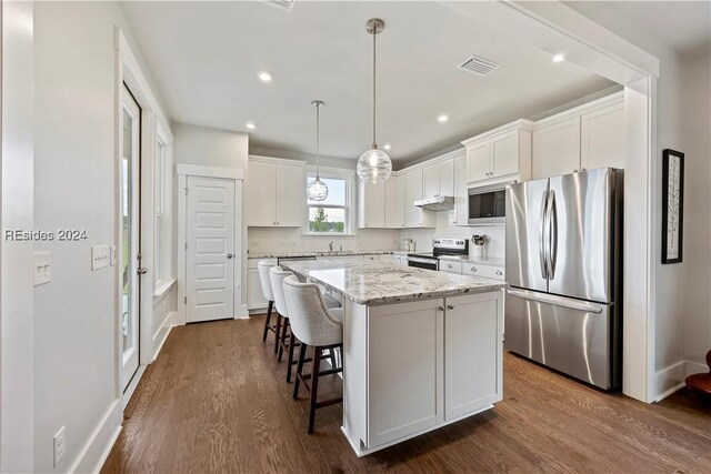 kitchen featuring appliances with stainless steel finishes, dark hardwood / wood-style floors, a center island, and white cabinets