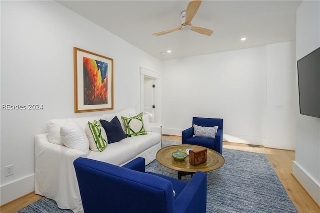 living room with ceiling fan and light hardwood / wood-style flooring