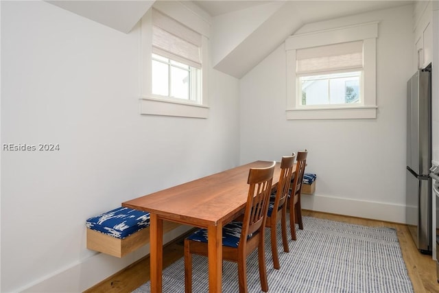 dining room featuring lofted ceiling and light hardwood / wood-style floors