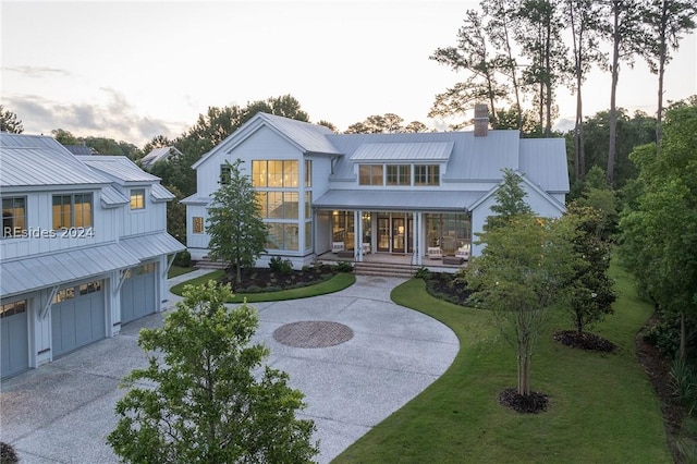 view of front of home with a yard, a garage, and a porch