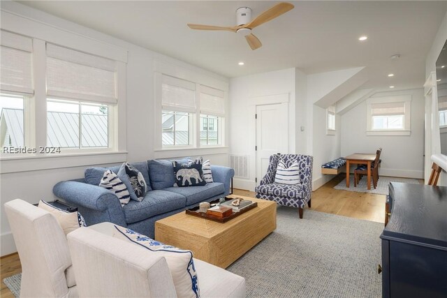 living room with light hardwood / wood-style flooring and ceiling fan