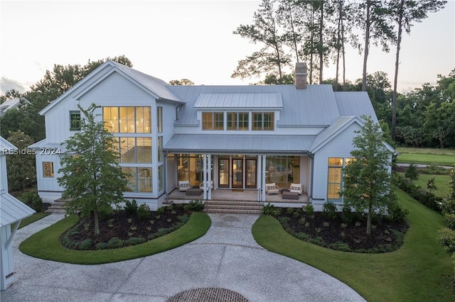 view of front of home with a porch and a lawn