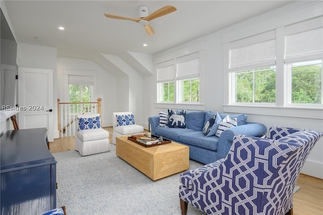 living room featuring lofted ceiling, hardwood / wood-style flooring, and ceiling fan