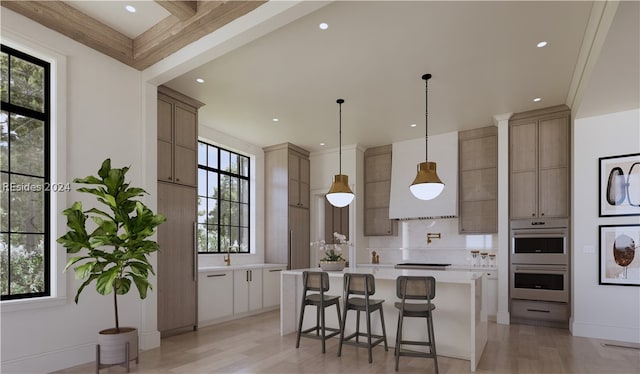 kitchen with hanging light fixtures, light hardwood / wood-style flooring, a kitchen breakfast bar, a kitchen island, and stainless steel double oven