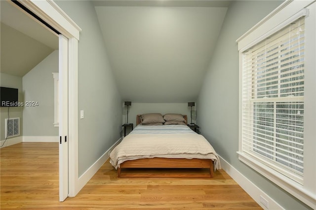 bedroom featuring vaulted ceiling and light wood-type flooring