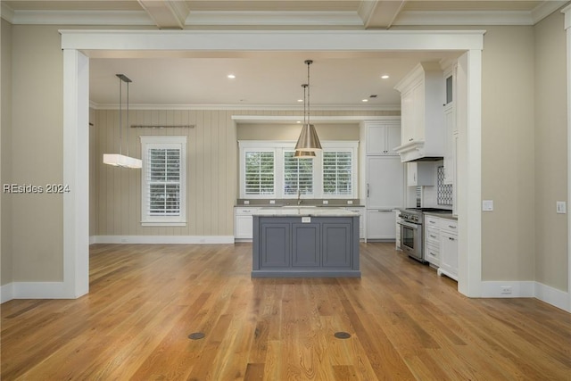 kitchen with pendant lighting, crown molding, white cabinetry, high end stainless steel range, and a kitchen island