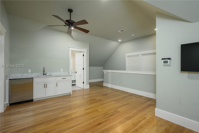 bonus room featuring vaulted ceiling, wet bar, ceiling fan, and light wood-type flooring