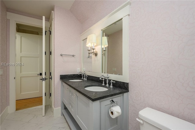 bathroom featuring vanity, lofted ceiling, and toilet