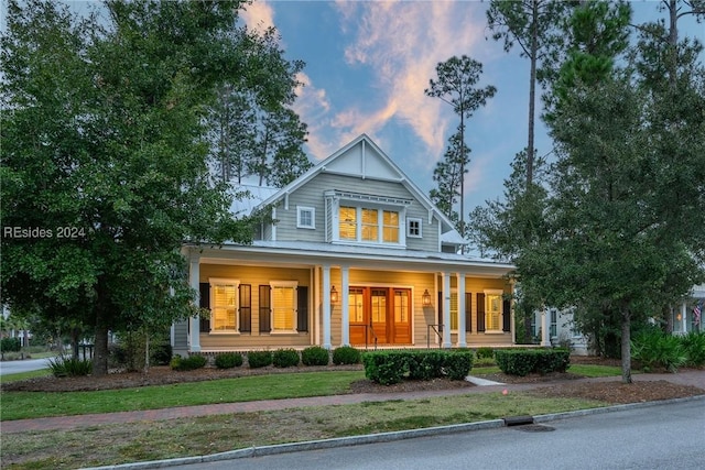 view of front facade featuring covered porch and a lawn