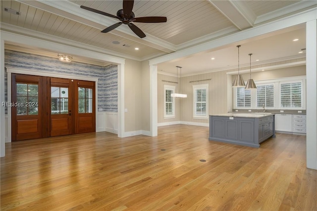 interior space featuring beamed ceiling, ornamental molding, light hardwood / wood-style flooring, and a wealth of natural light