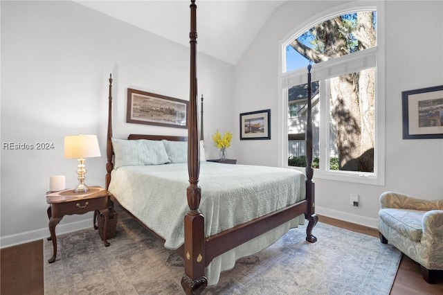 bedroom featuring multiple windows, vaulted ceiling, and wood-type flooring