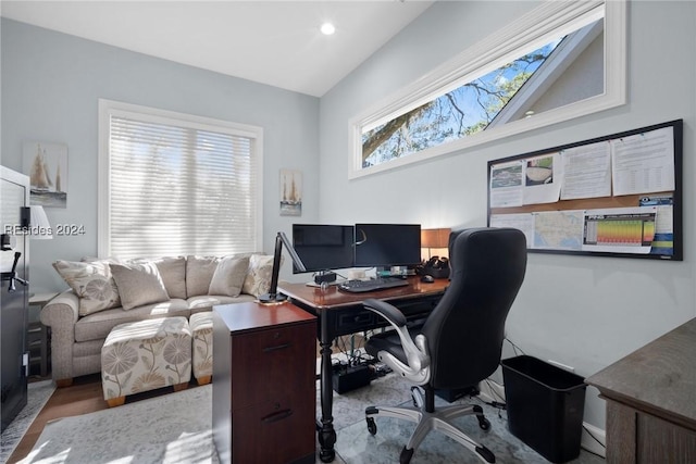 office space with vaulted ceiling and light hardwood / wood-style floors