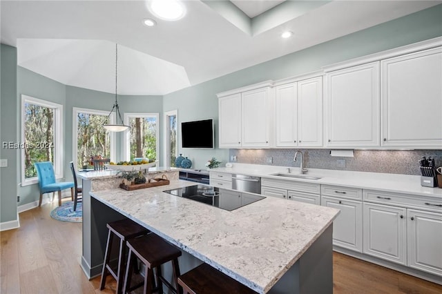 kitchen with white cabinetry, sink, black electric cooktop, and a center island