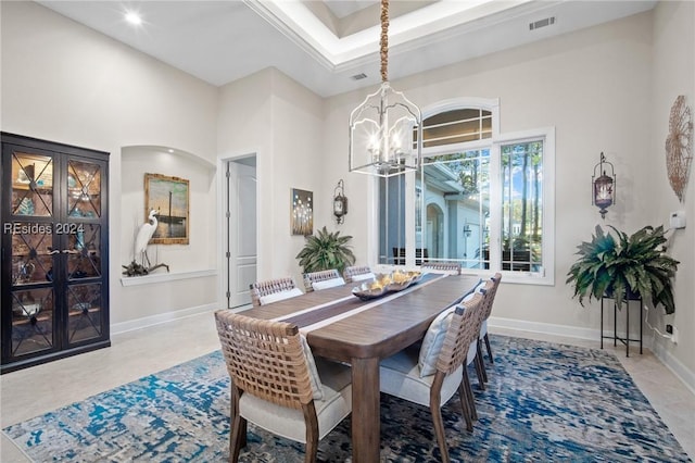 dining space featuring a towering ceiling and a chandelier