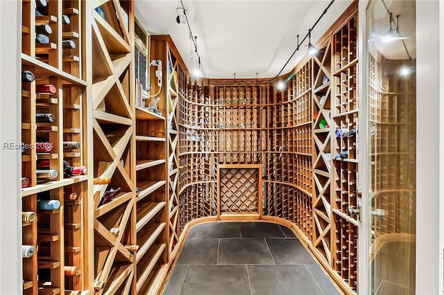 wine cellar with tile patterned floors and rail lighting