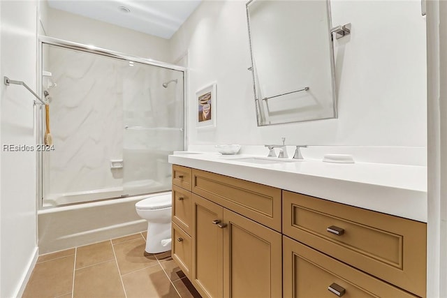 full bathroom with toilet, tile patterned floors, vanity, and bath / shower combo with glass door