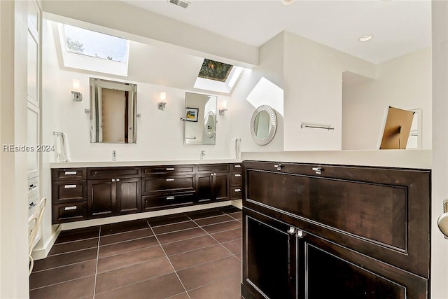 bathroom featuring vanity, tile patterned floors, and a skylight