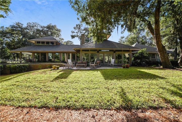 back of property featuring an outdoor hangout area and a lawn