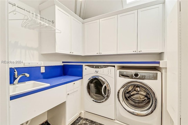 washroom featuring cabinets, sink, and washer and dryer