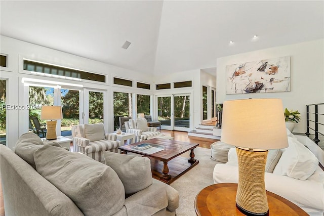 living room featuring light hardwood / wood-style floors and high vaulted ceiling