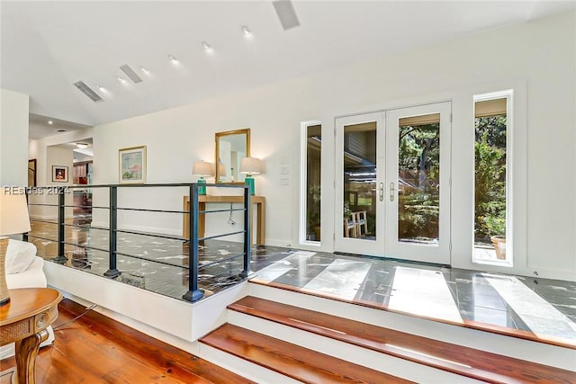 interior space with lofted ceiling, dark hardwood / wood-style floors, and french doors