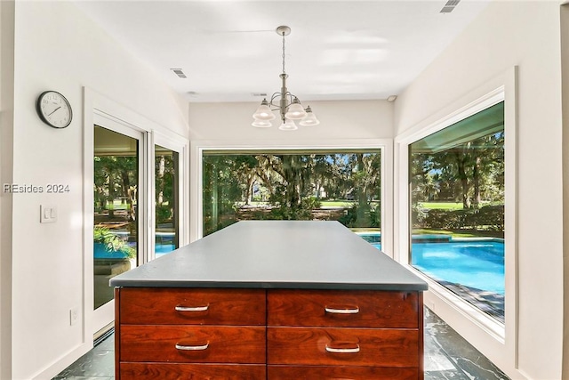 kitchen featuring an inviting chandelier, hanging light fixtures, and a kitchen island