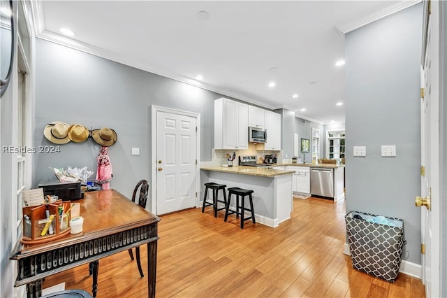 kitchen featuring a breakfast bar, white cabinetry, backsplash, kitchen peninsula, and stainless steel appliances