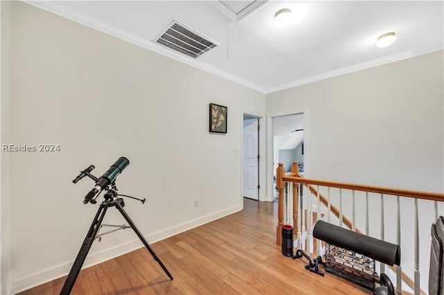 corridor with hardwood / wood-style flooring and crown molding