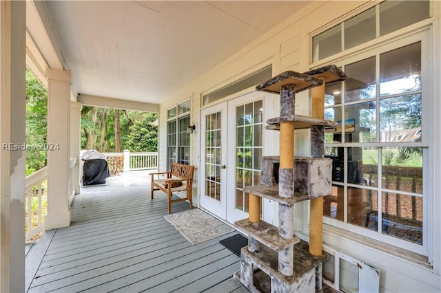 wooden terrace featuring grilling area, french doors, and a porch