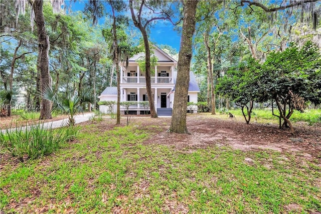 view of front of house with a front lawn, a balcony, and covered porch