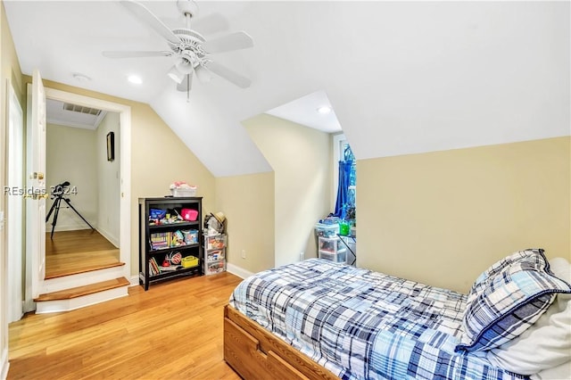 bedroom with ceiling fan, vaulted ceiling, and light wood-type flooring