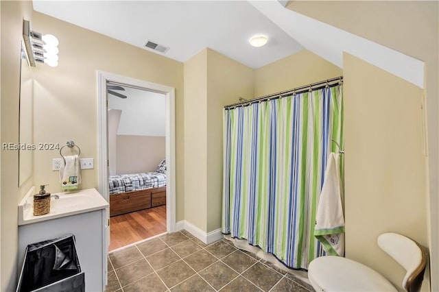 bathroom with tile patterned flooring, vanity, curtained shower, and toilet