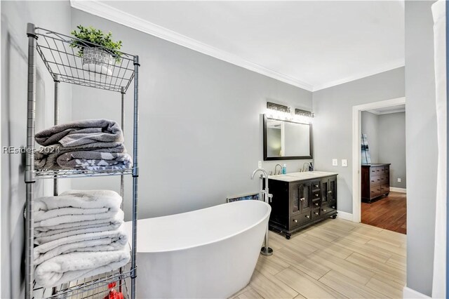 bathroom featuring vanity, a bath, and ornamental molding