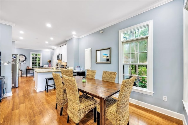 dining room with light hardwood / wood-style flooring and ornamental molding