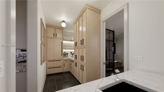 kitchen featuring light brown cabinetry and light stone countertops