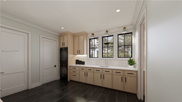 kitchen with sink, stacked washer / dryer, tasteful backsplash, dark hardwood / wood-style flooring, and light brown cabinets