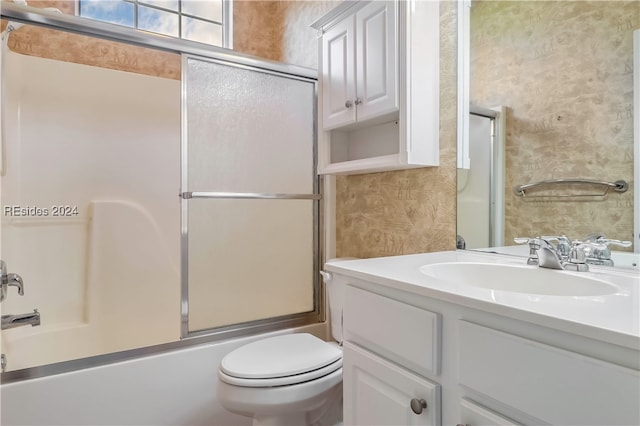 full bathroom featuring bath / shower combo with glass door, vanity, and toilet