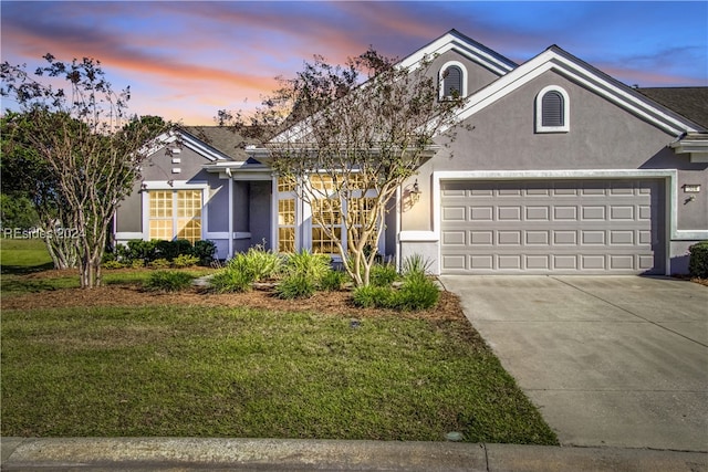 view of front of house featuring a garage and a lawn