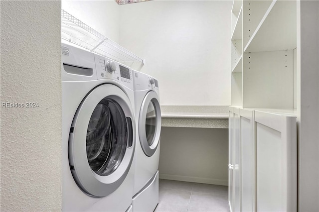 clothes washing area with independent washer and dryer and light tile patterned flooring