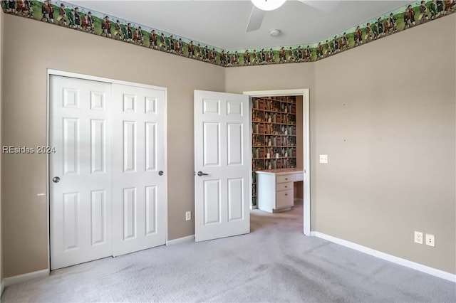 unfurnished bedroom with ceiling fan, light colored carpet, and a closet