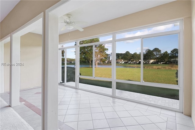 unfurnished sunroom with a water view and ceiling fan