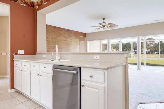 kitchen with sink, ceiling fan, white cabinets, stainless steel dishwasher, and light colored carpet