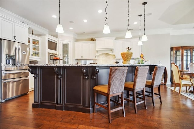 kitchen featuring a spacious island, decorative light fixtures, and stainless steel fridge with ice dispenser