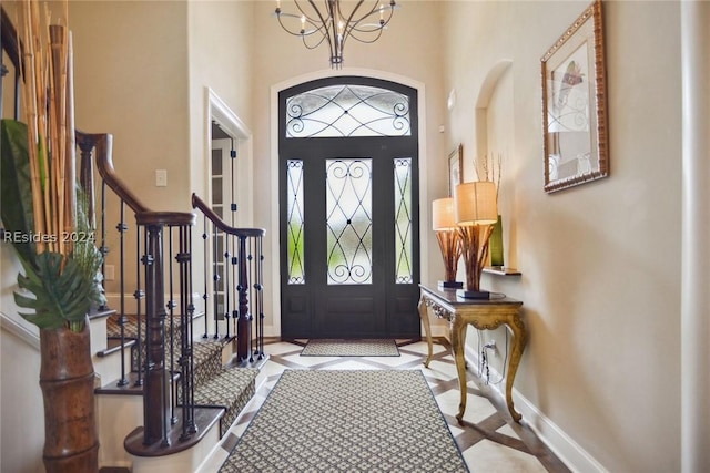 foyer entrance with a high ceiling and a notable chandelier