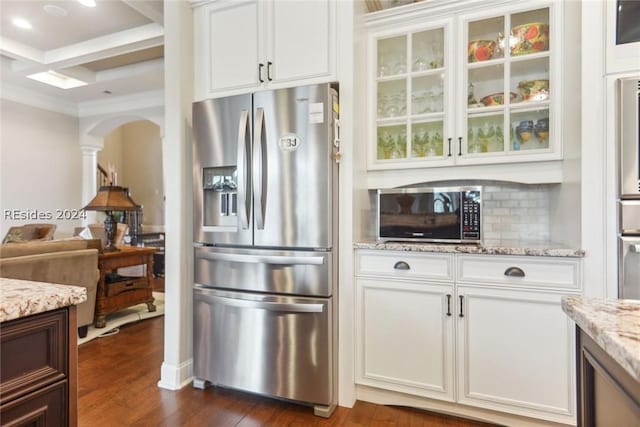 kitchen featuring white cabinetry, coffered ceiling, stainless steel refrigerator with ice dispenser, light stone countertops, and beam ceiling